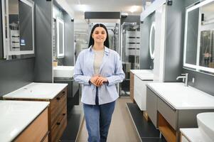 magnifique Jeune femme dans une meubles boutique regards à le meubles dans le salle de bains photo