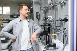 une acheteur achats pour salle de bains équipement dans Matériel magasin. émouvant robinet grue ou l'eau robinet photo