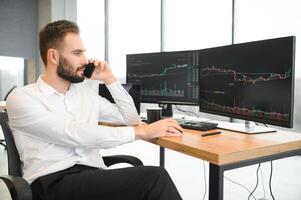 affaires homme à la recherche à le graphiques de le Stock marché de cryptomonnaies sur le PC écran photo