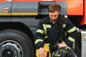 déprimé et fatigué sapeur pompier près Feu un camion photo