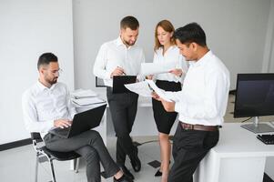 équipe au travail. groupe de jeunes gens d'affaires en vêtements décontractés intelligents travaillant ensemble dans un bureau créatif photo