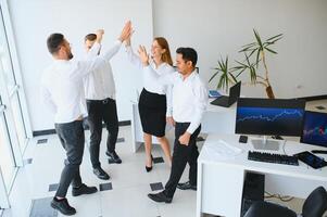 content réussi multiracial affaires équipe donnant une haute cinq geste comme elles ou ils rire et acclamation leur succès. photo