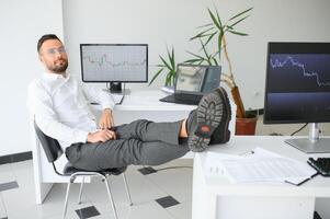Jeune homme d'affaire est relaxant à lieu de travail et a le sien pieds sur bureau dans bureau. photo