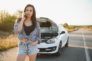 magnifique sexy femme près une cassé auto. confus femme Est-ce que ne pas connaître quoi à faire photo