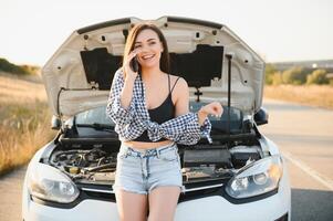 magnifique sexy femme près une cassé auto. confus femme Est-ce que ne pas connaître quoi à faire photo