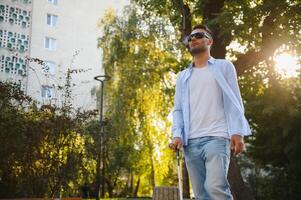 aveugle homme en marchant sur trottoir en portant bâton. photo