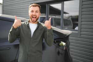 homme mise en charge électrique voiture par le maison photo