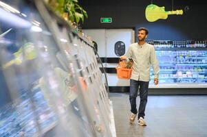 portrait de Indien Masculin dans épicerie avec positif attitude photo