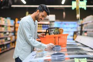 portrait de Indien Masculin dans épicerie avec positif attitude photo