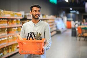 portrait de Indien Masculin dans épicerie avec positif attitude photo