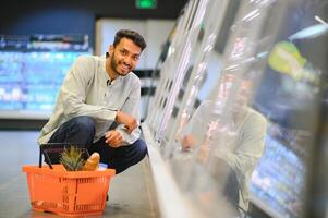 portrait de Indien Masculin dans épicerie avec positif attitude photo