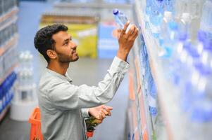 portrait de Indien Masculin dans épicerie avec positif attitude photo