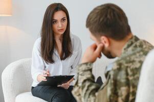parler au médecin. un soldat a une séance de thérapie avec un psychologue à l'intérieur photo