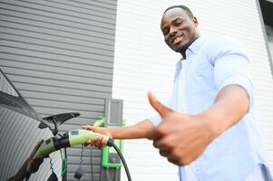 africain américain homme mise en charge le sien électrique auto. photo