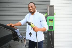 africain américain homme mise en charge le sien électrique auto. photo