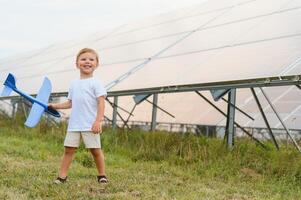 une peu garçon est ayant amusement près le solaire panneaux. le concept de solaire énergie. photo