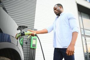 homme bouchage dans électrique voiture à l'extérieur Bureau dans voiture parc mise en charge photo