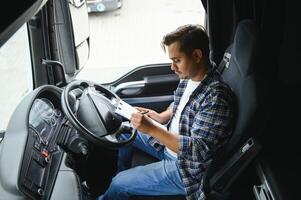 une Jeune Indien Masculin un camion chauffeur est assis derrière le roue photo