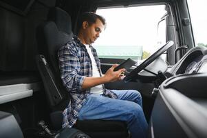 une Jeune Indien Masculin un camion chauffeur est assis derrière le roue photo