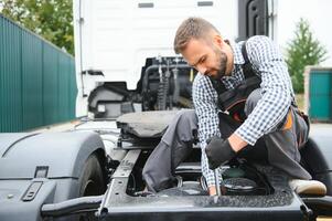 homme dans uniforme. un camion réparation. voiture mauvais fonctionnement. photo