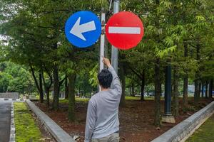 homme Regardez à le signe direction circulation. le photo est adapté à utilisation pour aventure et Voyage destination contenu médias.