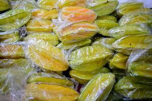 caramboles dans transparent Plastique affiché dans marché fruit photo