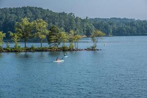 kayakistes sur le Lac dans heure d'été photo