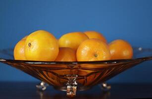 une verre bol avec mandarines photo