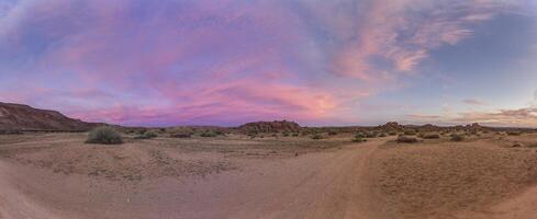 panoramique image de une coloré le coucher du soleil plus de le veld dans du sud Namibie avec une rose jouer de couleurs photo