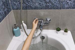 recadrer le robinet de bain touchant la main photo