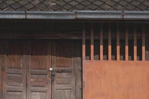 Contexte de grunge en bois pliant porte avec métal glissement entrée porte et argile tuile toit de le vieux rustique maison photo