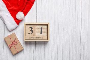 Noël chapeau, cadeau et en bois calendrier 31 décembre sur une en bois Contexte photo