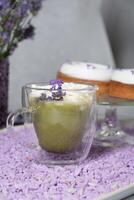 matcha vert thé avec mousse Gâteaux sur une table décoré avec lavande fleurs photo