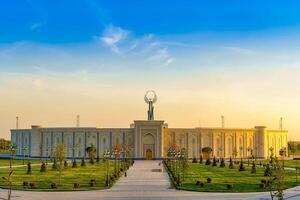 Ouzbékistan, Tachkent - avril 25, 2023 le territoire de le parc Nouveau Ouzbékistan avec monument de indépendance dans le forme de une stèle avec une humo oiseau à crépuscule. photo