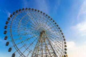 haute ferris roue à le coucher du soleil ou lever du soleil avec nuageux ciel Contexte. photo