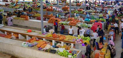 samarcande, Ouzbékistan - avril 27, 2023 Haut vue de Lignes de fruit et légume stalles et vendeurs dans un Oriental bazar dans central Asie. photo