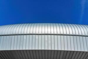une moderne bâtiment couvert avec métal aluminium panneaux contre le bleu ciel. photo