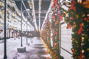 Noël ou Nouveau années marché dans une L'Europe  avec Maisons décoré avec jouet des balles et guirlandes à nuit. ancien film esthétique. photo