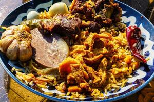 Haut vue de une assiette avec ouzbek Oriental pilaf avec pièces de agneau, cheval Viande, Caille riz et poulet œuf. asiatique cuisine. photo