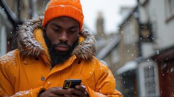 une homme portant un Orange veste est concentré sur le sien cellule téléphone écran photo