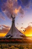 Ouzbékistan, Tachkent - octobre 4, 2023 monument de indépendance dans le forme de une stèle avec une humo oiseau sur une crépuscule avec Cliody ciel dans le Nouveau Ouzbékistan parc. photo