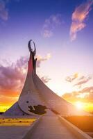 Ouzbékistan, Tachkent - octobre 4, 2023 monument de indépendance dans le forme de une stèle avec une humo oiseau sur une crépuscule avec Cliody ciel dans le Nouveau Ouzbékistan parc. photo