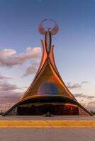 Ouzbékistan, Tachkent - octobre 4, 2023 monument de indépendance dans le forme de une stèle avec une humo oiseau sur une crépuscule avec Cliody ciel dans le Nouveau Ouzbékistan parc. photo