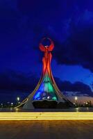 Ouzbékistan, Tachkent - octobre 4, 2023 illuminé monument de indépendance dans le forme de une stèle avec une humo oiseau dans le Nouveau Ouzbékistan parc à la nuit dans l'automne. photo