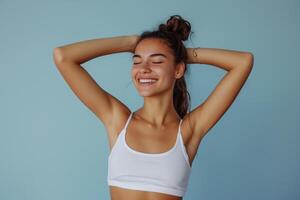 radiant Jeune femme souriant avec yeux fermé dans décontractée tenue de sport. photo