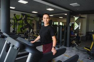 attrayant Jeune des sports femme est travail en dehors dans salle de sport. Faire cardio formation sur tapis roulant. fonctionnement sur tapis roulant photo