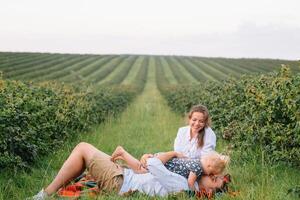 content famille avec peu fille dépenses temps ensemble dans ensoleillé champ photo