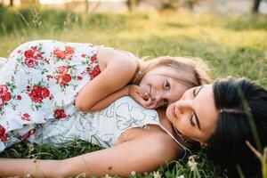 mère et fille ayant amusement dans le parc. bonheur et harmonie dans famille vie. beauté la nature scène avec famille Extérieur mode de vie photo