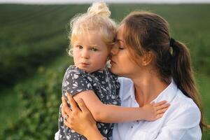 élégant mère et fille ayant amusement sur le la nature. content famille concept. beauté la nature scène avec famille Extérieur mode de vie. content famille repos ensemble. bonheur dans famille vie. les mères journée photo