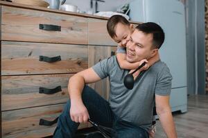 Jeune homme et le sien fils avec four feuille dans cuisine. père avec peu fils sur le cuisine photo